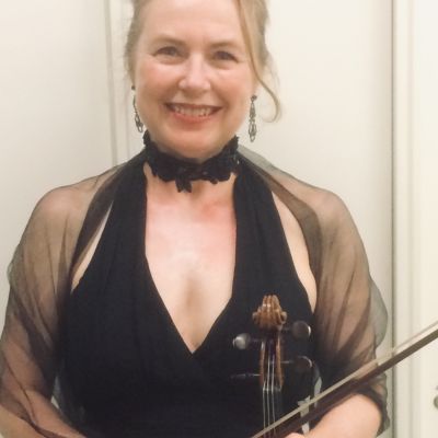 Julia Stewart wears a black dress and holds a violin
